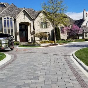 Photo of a luxury residential home with Powerhouse Pete's truck in the driveway with cleaned brick pavers